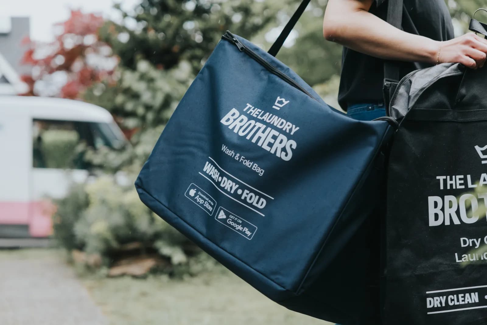 A Laundry Brothers driver delivering a clean wash & fold bag at the door of a Vancouver home.